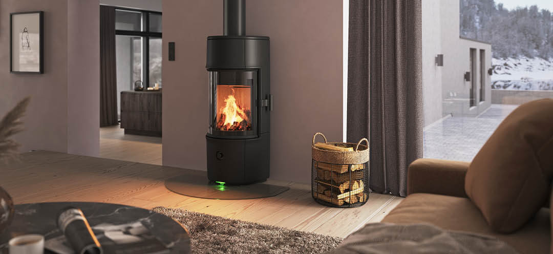 Modern room with small black Jøtul F 171 wood stove, powder-purple walls, and snowy mountain view