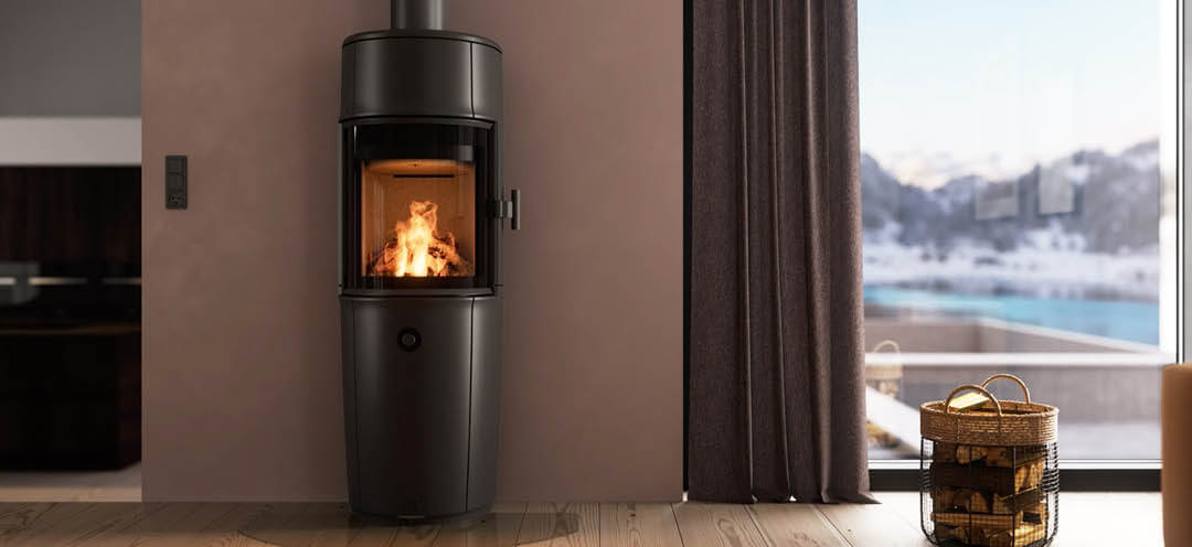 Modern room with large black Jøtul F 174 wood stove, powder-purple walls, and snowy mountain view